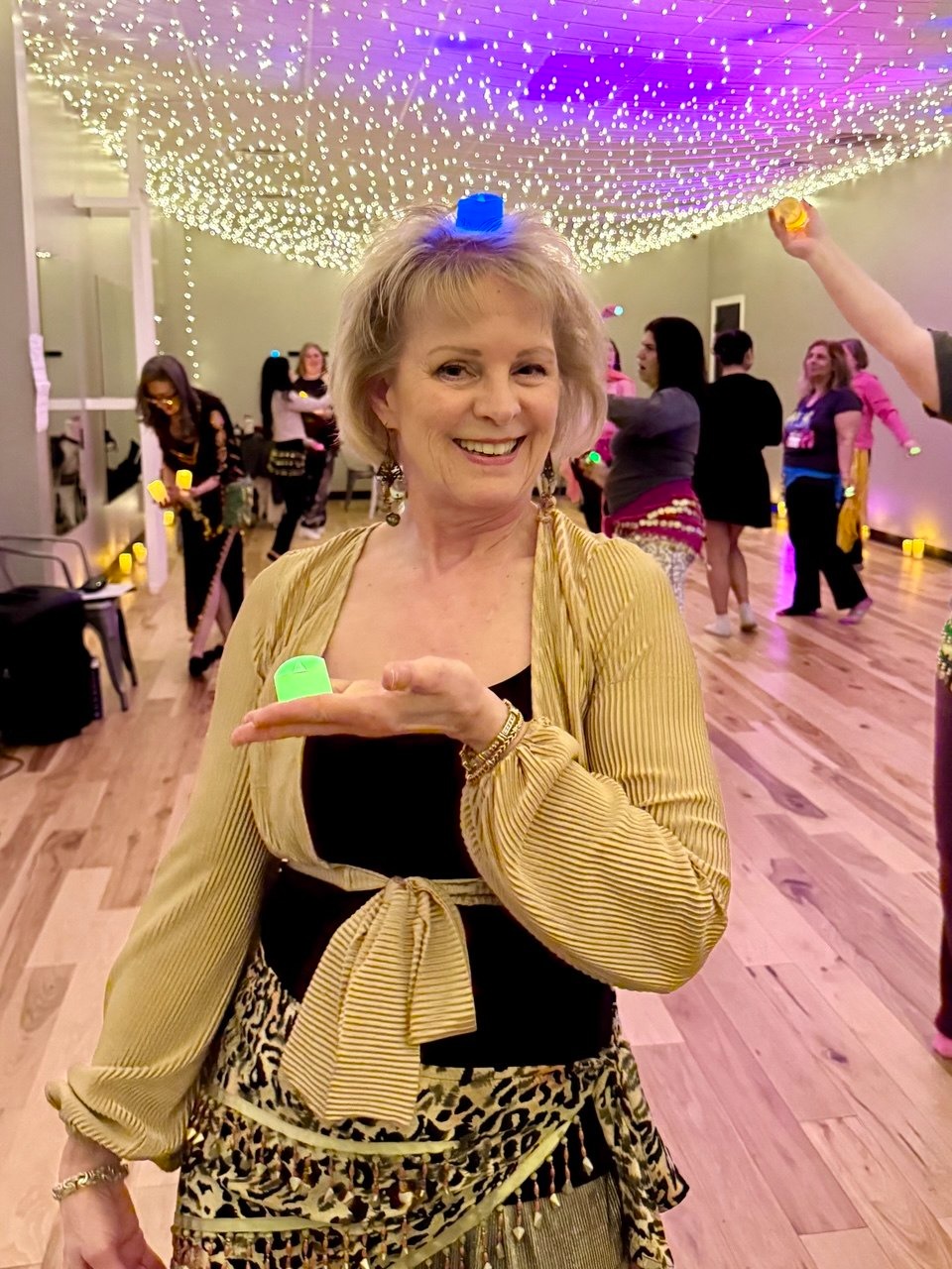 Mulher sorrindo segurando uma velinha LED no estúdio
