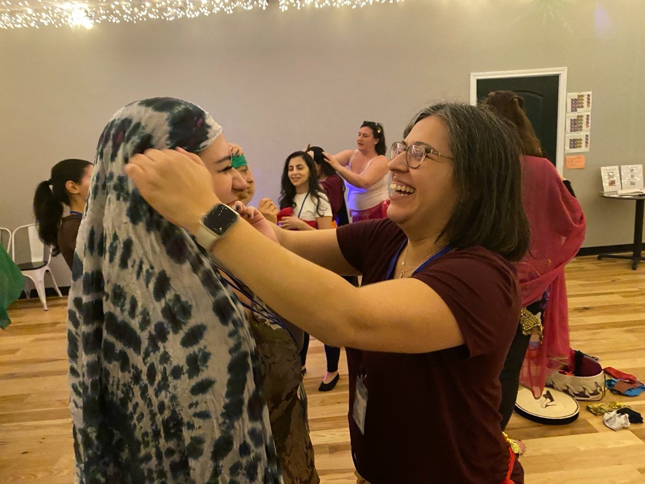 Mulher rindo enquanto ajusta o véu de outra